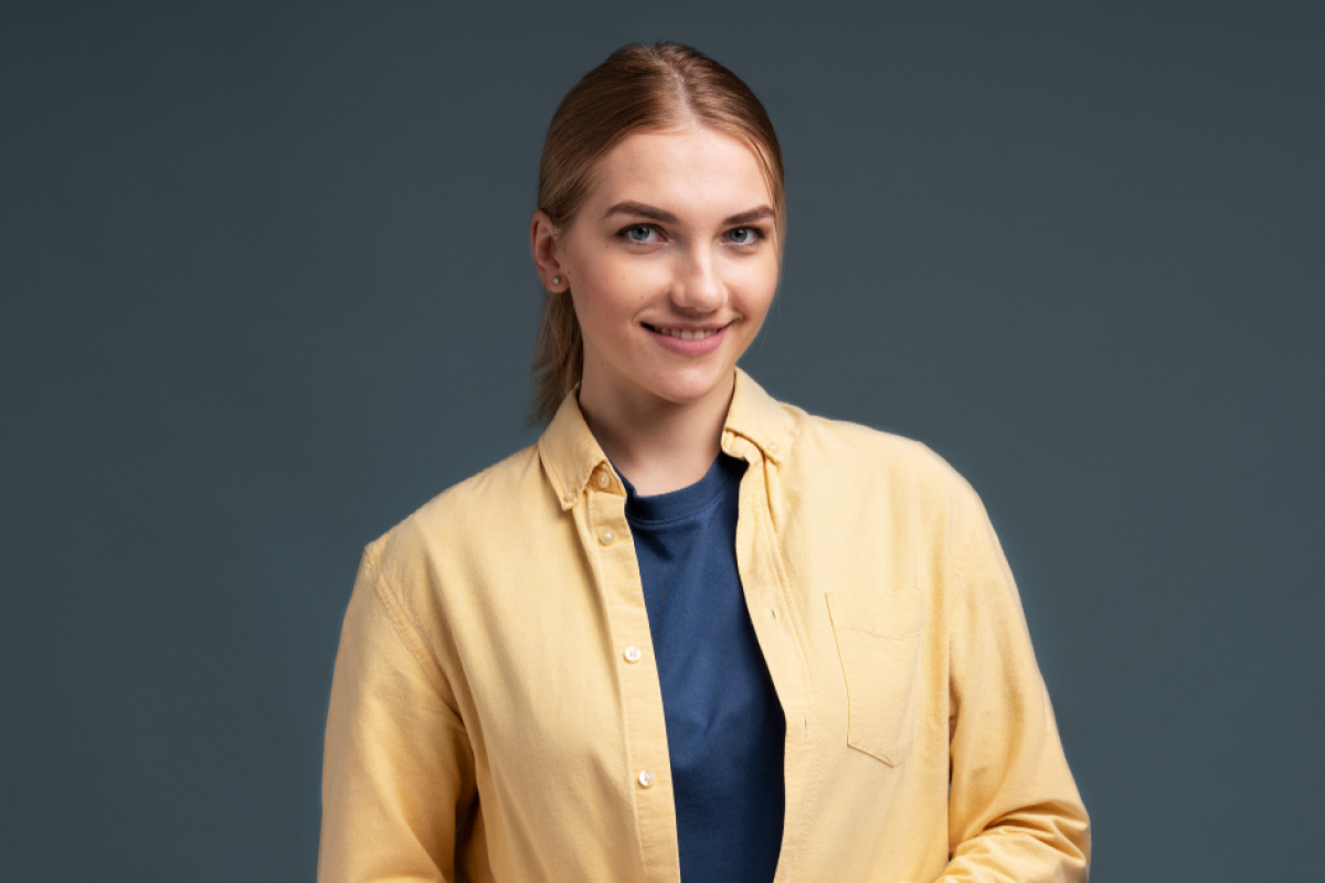 Smiling woman in a yellow shirt, representing financial tips for holiday business preparation.