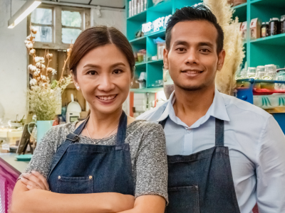 Business owners smiling in a cafe, representing growth through purchase order funding and financial solutions.