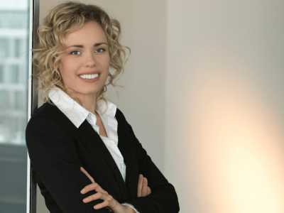 Professional woman smiling in business attire, representing B2B social media marketing strategies and engagement.