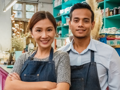 Business owners smiling in a cafe, representing growth through purchase order funding and financial solutions.