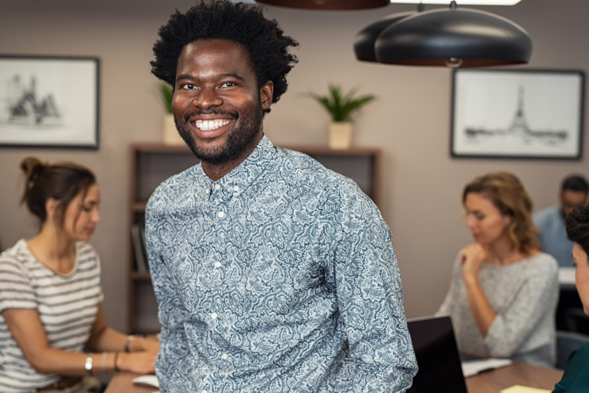 Smiling businessman in a modern office, representing flexible purchase order loans for business growth.