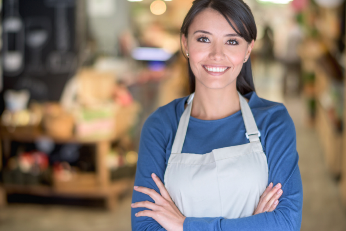 Smiling business owner in an apron, showcasing social media marketing potential for small businesses.