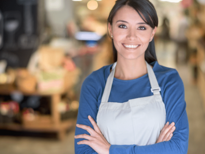 Smiling business owner in an apron, showcasing social media marketing potential for small businesses.