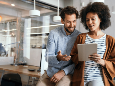 Business professionals discussing financial strategies while reviewing a tablet in a modern office setting.
