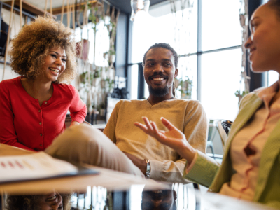 Group of diverse professionals engaging in a friendly discussion over coffee, emphasizing customer loyalty and relationships.