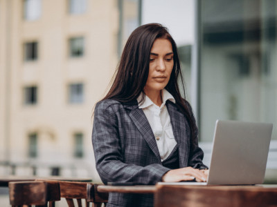 Business professional using marketing automation tools on a laptop outdoors, enhancing small business growth and efficiency.
