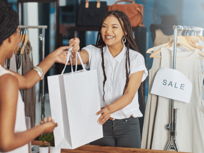 Happy customers receiving purchases in a retail store, highlighting small business success and cash flow solutions.