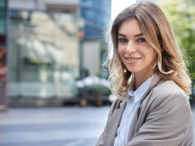 Smiling professional woman in a city setting, promoting team building and productivity through strategic breaks and play-time.