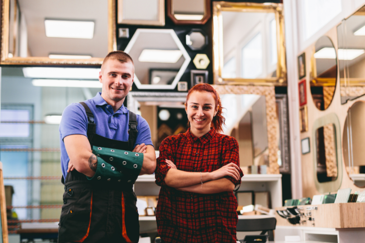 Small business owners in a frame shop smiling, representing essential tax deadlines and financial planning.