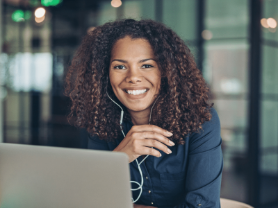 Smiling businesswoman using cloud software on a laptop, showcasing the benefits of cloud computing for small businesses.