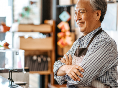 Smiling business owner in a cafe, representing accounts receivable funding for cash flow enhancement and business growth.