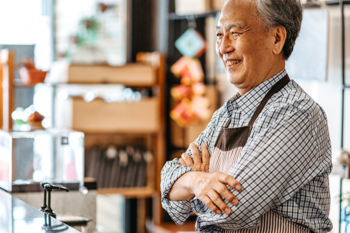 Smiling business owner in a cafe, representing accounts receivable funding for cash flow enhancement and business growth.