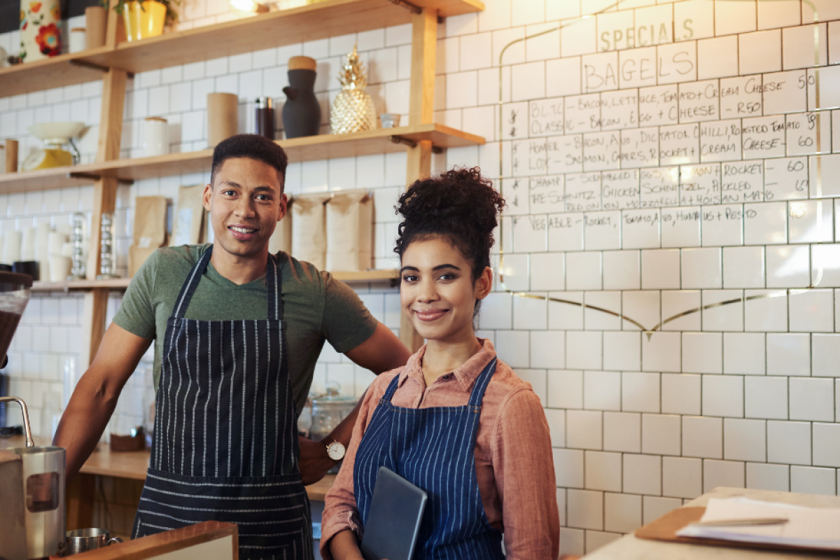 Small business owners in a cafe setting, showcasing productivity tips and teamwork in a vibrant workspace.