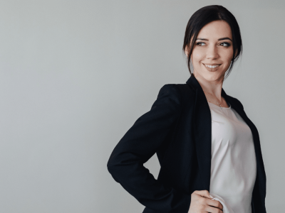 Professional woman in a blazer smiling, representing small business success and mobile marketing strategies.