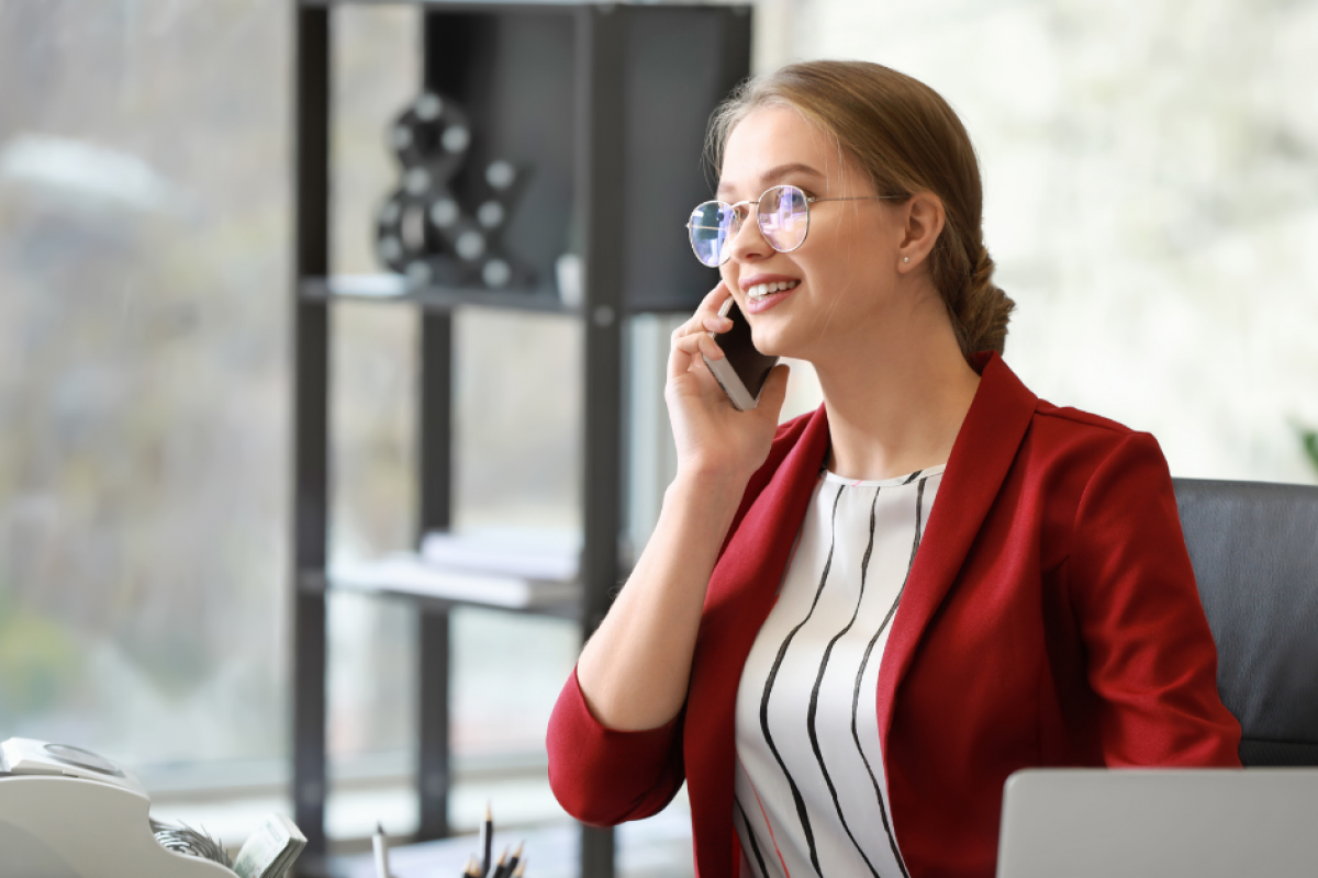 Professional woman on the phone in a modern office, representing business growth and customer service excellence.