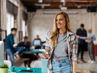 Smiling woman in a modern office, representing small business success and the benefits of small business loans.