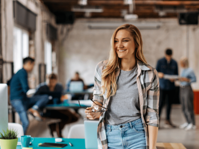Smiling woman in a modern office, representing small business success and the benefits of small business loans.