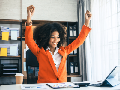 Business owner celebrating success in an office, representing growth and hiring with Advance Funds Network.