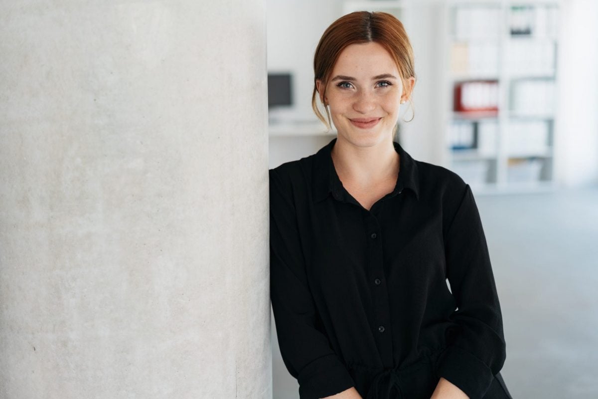 Smiling woman in a black shirt, representing business support and merchant cash advances for entrepreneurs.