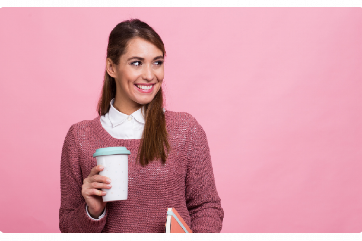 Smiling woman holding a coffee cup and notebook, representing small business empowerment and financing solutions.