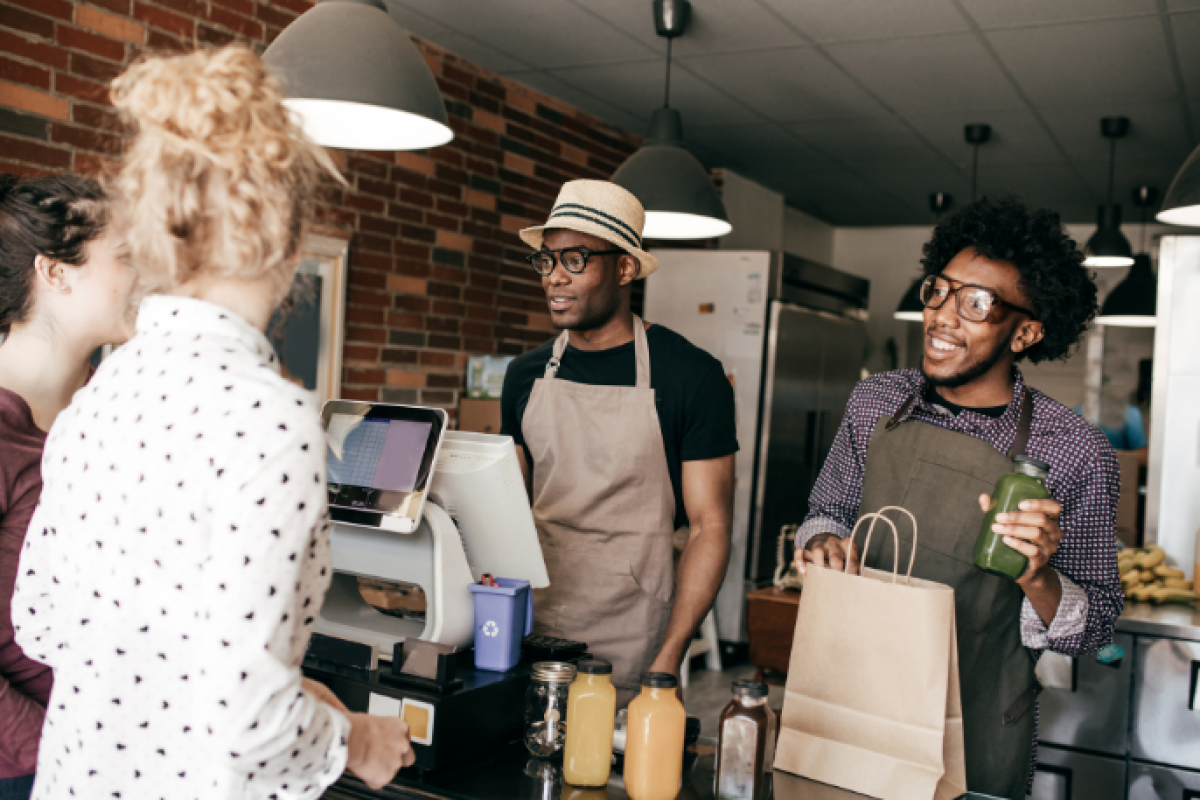 Business owners discussing strategic financial decisions at a cafe, emphasizing growth and customer engagement.