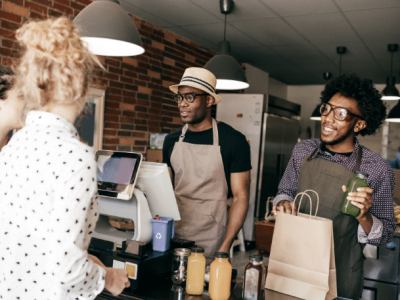 Business owners discussing strategic financial decisions at a cafe, emphasizing growth and customer engagement.