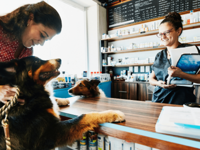 Pet store financing solutions with happy customers and pets at the counter, showcasing flexible credit options for growth.