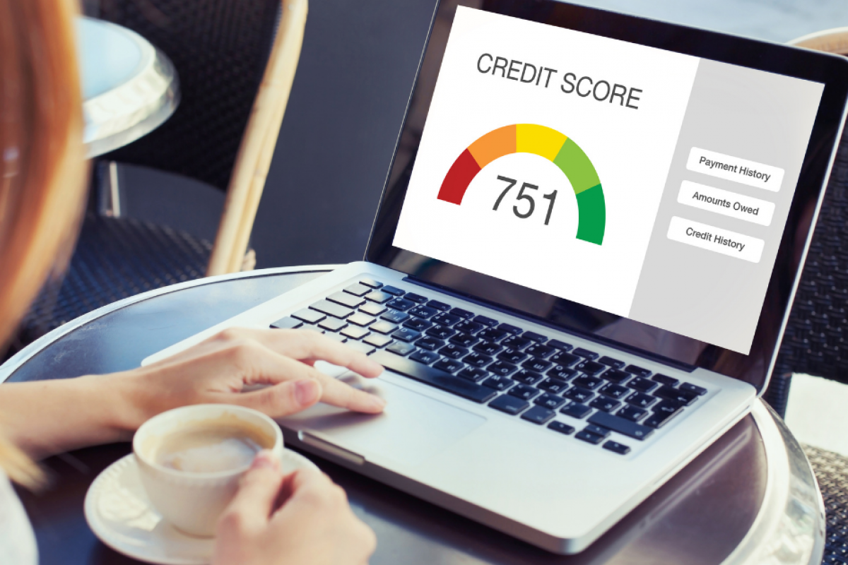 Business credit score monitoring on laptop, showing a score of 751 with key factors like payment history and amounts owed.