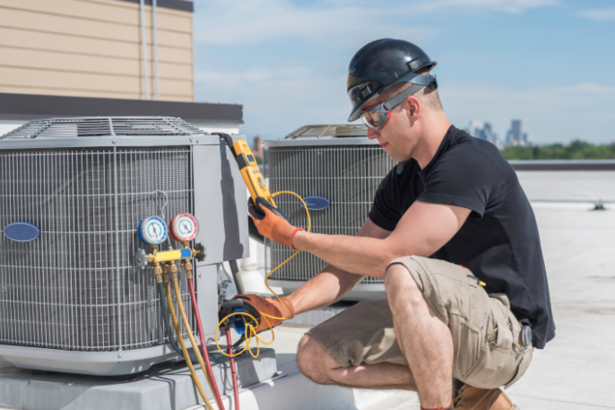 HVAC technician servicing air conditioning units, highlighting summer business growth and financing options for HVAC professionals.