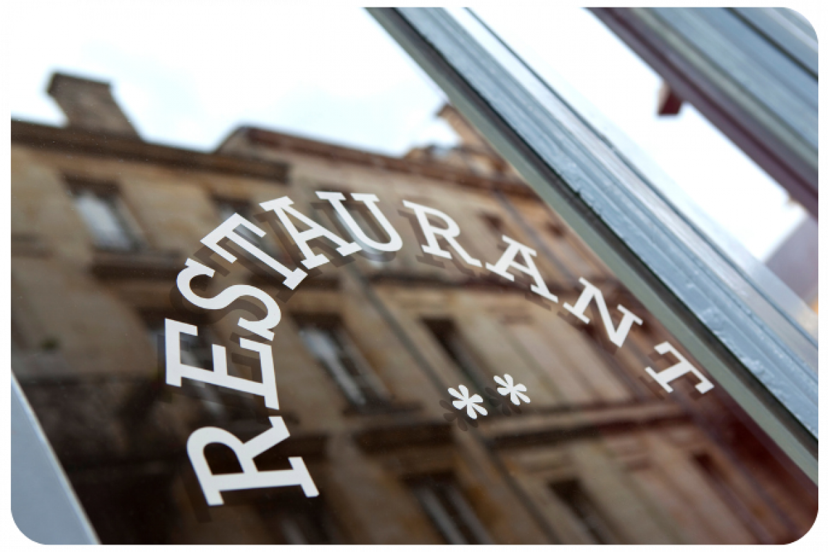 Restaurant entrance sign reflecting the importance of cash flow and effective management for restaurant success.